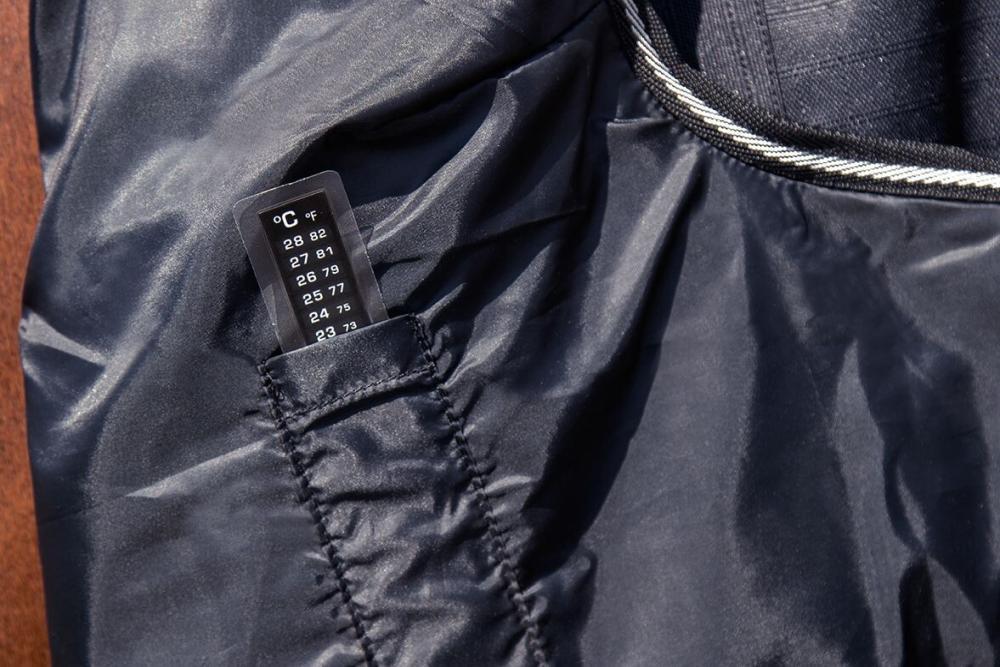 HKM Highneckdecke Innsbruck - 1200 D, 200 g Wattefüllung, schwarz Detailansicht der schwarzen HKM Highneck Pferdedecke Innsbruck mit integriertem Thermometer-Etikett im Innenfutter.