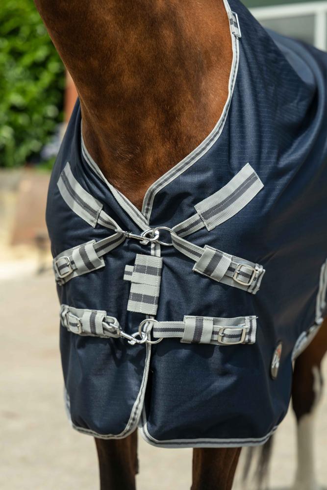 Nahaufnahme des Brustverschlusses der HKM Weidedecke ThermoPro mit Halsteil in dunkelblau und grau am Pferd.