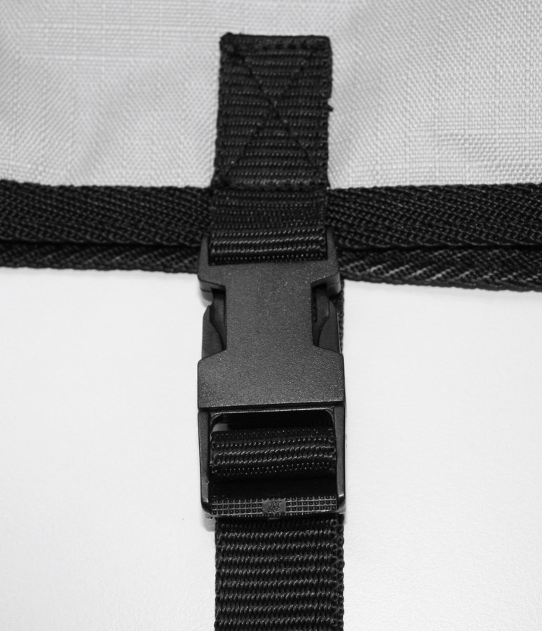 Detailansicht des schwarzen Kunststoffverschlusses der Kerbl Kälberdecke Ripstopp mit robustem Gurtband.