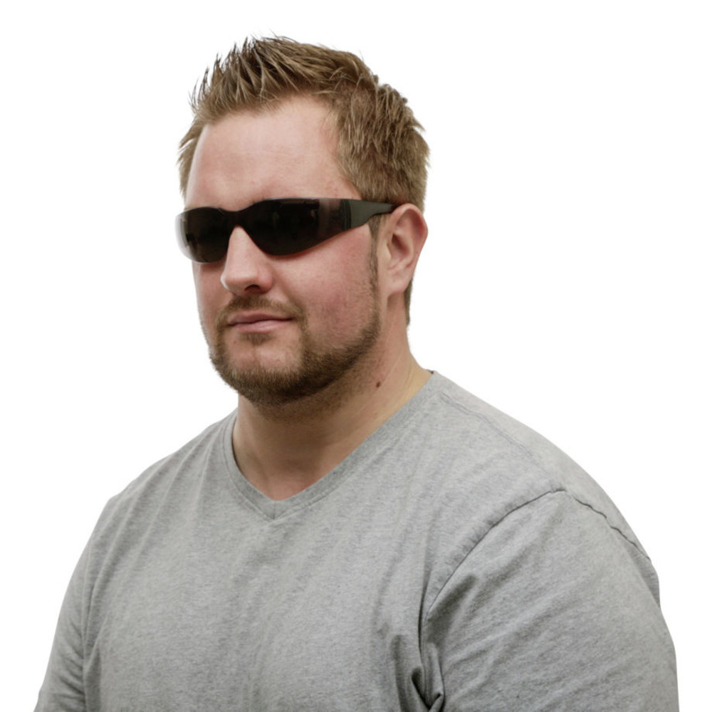 Schutzbrille Light-K in sportlicher Form mit schwarzem Rahmen und getönten Gläsern, von einem Mann getragen.