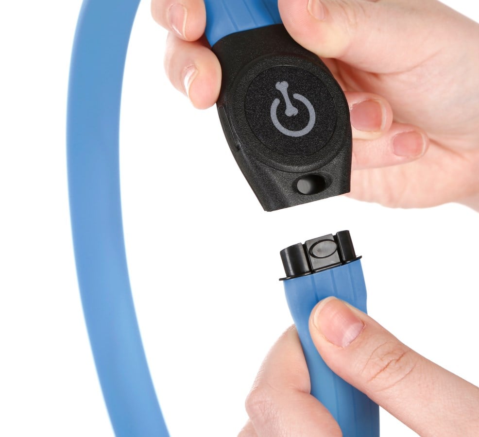 Hände öffnen den schwarzen Kunststoffverschluss des blauen Kerbl LED-Halsbands Maxi Safe in einer Nahaufnahme