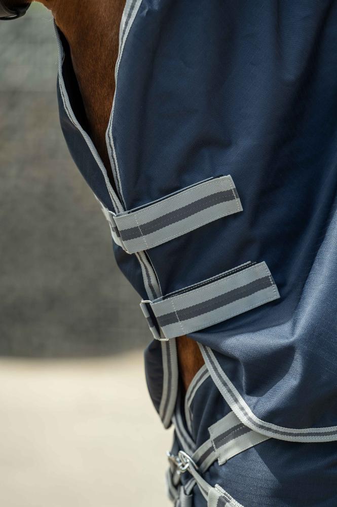 Doppelter Brustverschluss der HKM Weidedecke ThermoPro in dunkelblau mit grauen Gurten, Klett und Schnallen am Pferd.