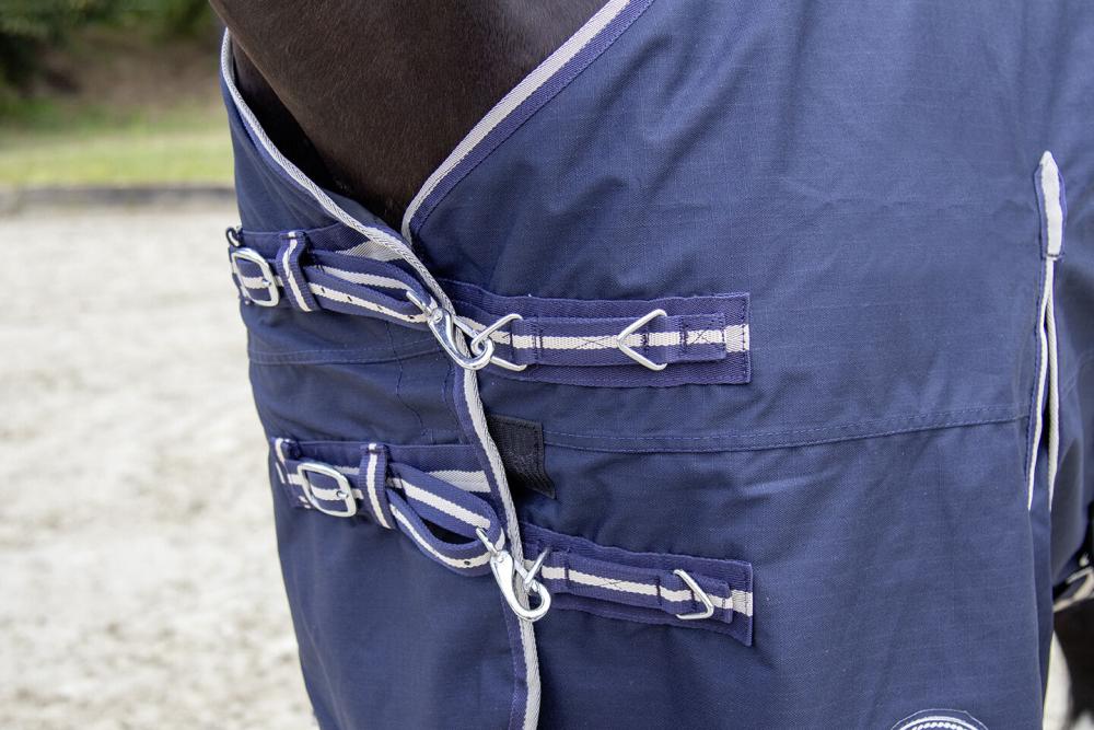 HKM Weidedecke Eco-Light Winter mit 300 g Wattefüllung, dunkelblau HKM Abschwitzdecke Eco-LightWinter in dunkelblau. Nahaufnahme des doppelten Brustverschlusses mit Metallschnallen.