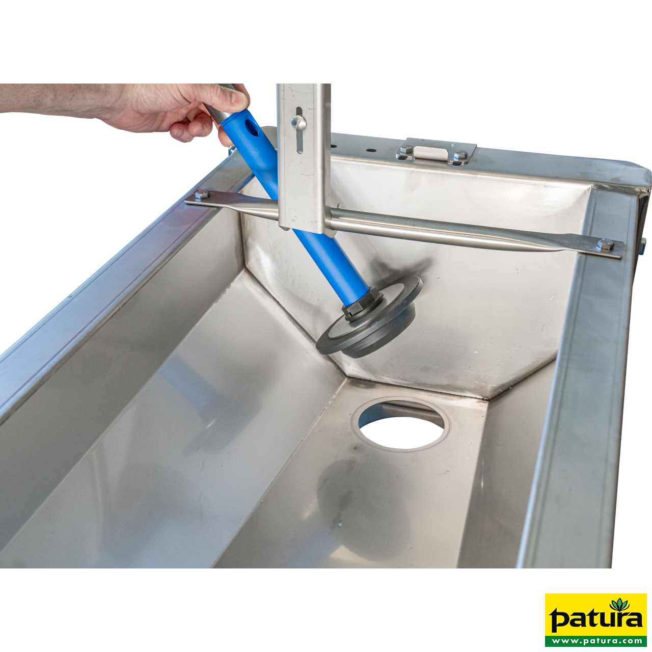 Nahaufnahme des Schnellablauf-Trogs aus Edelstahl, bei dem der blaue Ablaufstopfen von Hand angehoben wird.