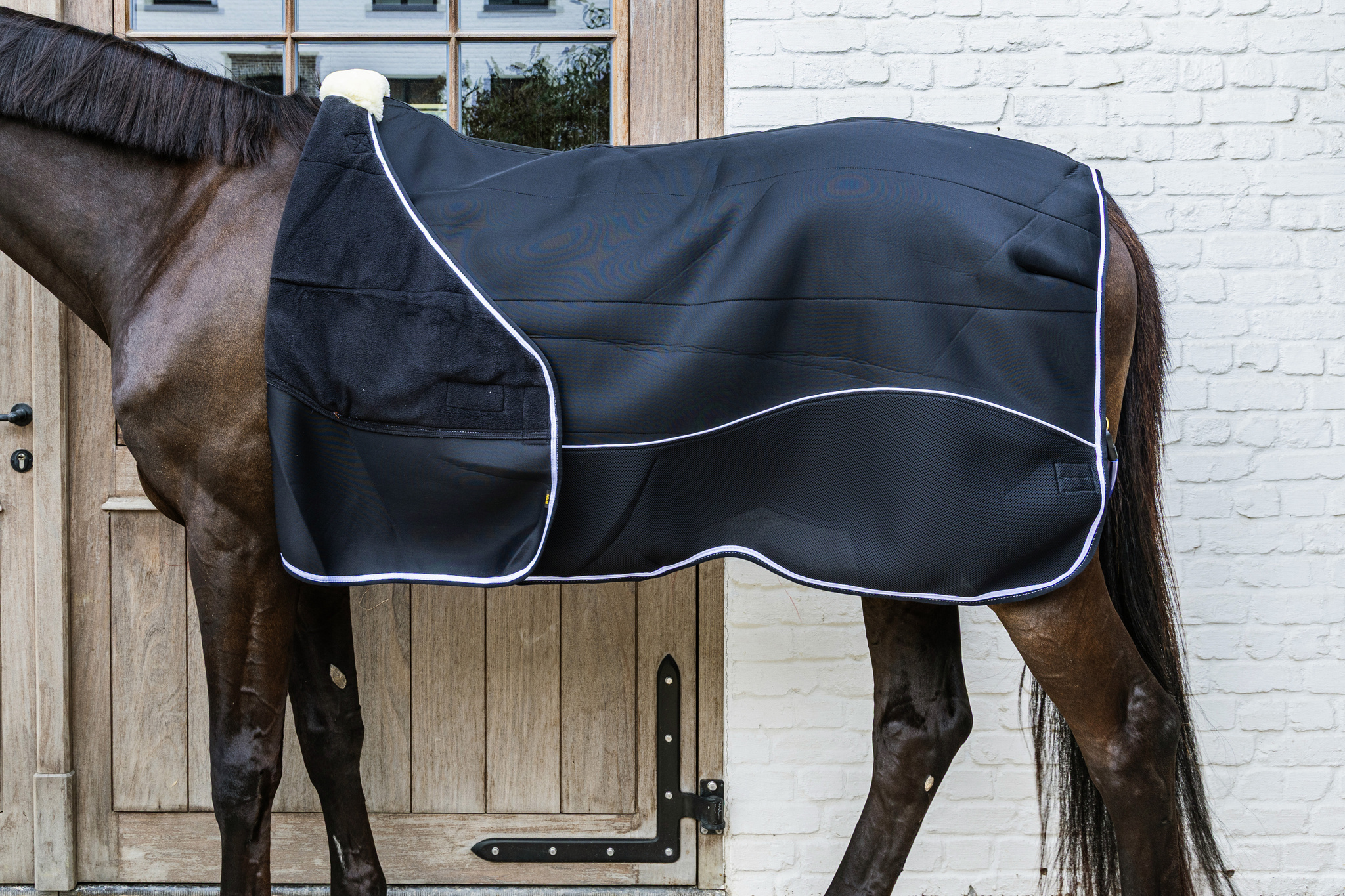 KENTUCKY® HORSEWEAR Turnout Rug Comfort 3D Fleece Liner, schwarz Schwarze Turnoutdecke Comfort 3D Fleece Liner am Pferd in Seitenansicht, mit Fleecefutter und weißer Einfassung.
