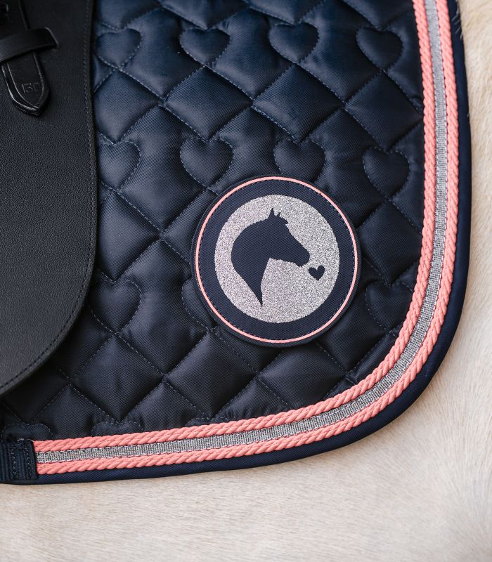 Detailansicht der dunkelblauen WALDHAUSEN Schabracke Lucky mit Herzsteppung, rosa Kordel und Glitzer-Patch.