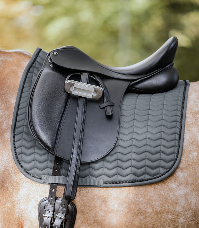 WALDHAUSEN Schabracke Classic Dressur, grau/schwarz WALDHAUSEN Schabracke Classic Dressur in Grau mit schwarzer Kordel und Zickzack-Steppung auf einem Pferderücken.