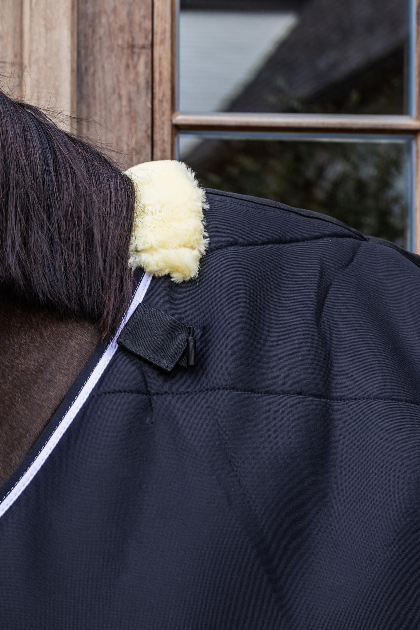 KENTUCKY® HORSEWEAR Turnout Rug Comfort 3D Fleece Liner, schwarz Schwarze Turnoutdecke Comfort 3D Fleece Liner am Pferd, Nahaufnahme des cremefarbenen Fleece-Widerristpolsters.