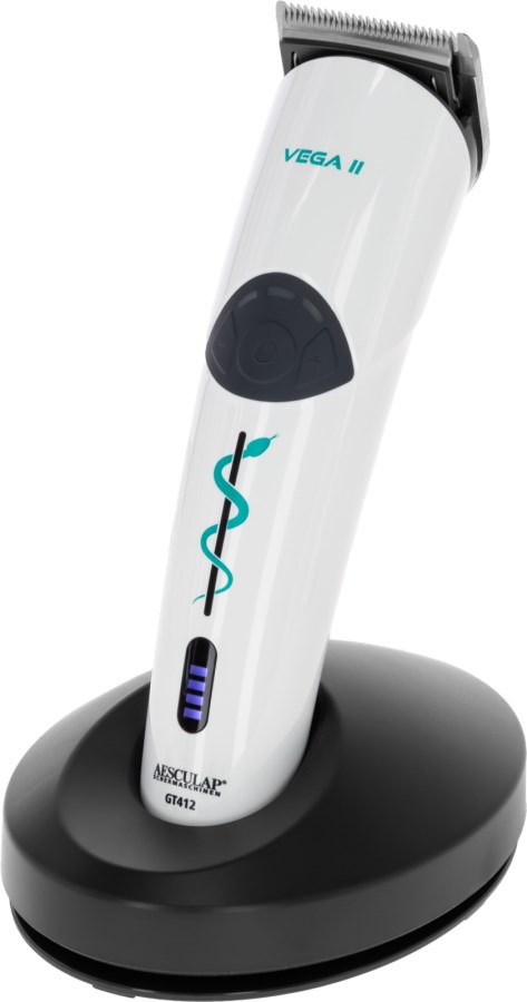 Weiße Akkuschermaschine AESCULAP Vega II für den Veterinärbedarf in der schwarzen Ladestation mit Akkuanzeige.