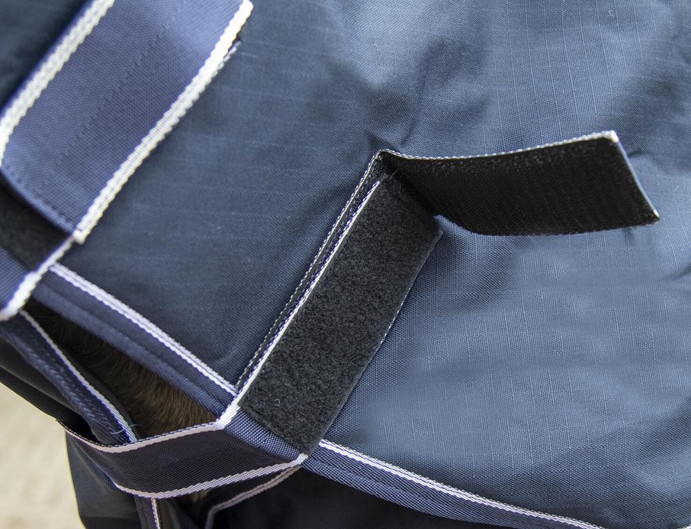HKM Weidedecke Starter mit Halsteil und Polarfleece, dunkelblau Detailansicht des Klettverschlusses der dunkelblauen HKM Starter Fleecedecke mit Halsteil und weißen Ziernähten.