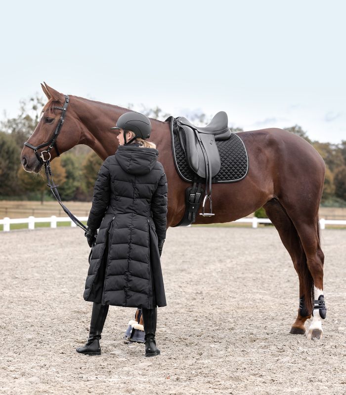 Schwarze WALDHAUSEN Dressur-Schabracke Felix Glam mit Zierkordel, am gesattelten braunen Pferd getragen.