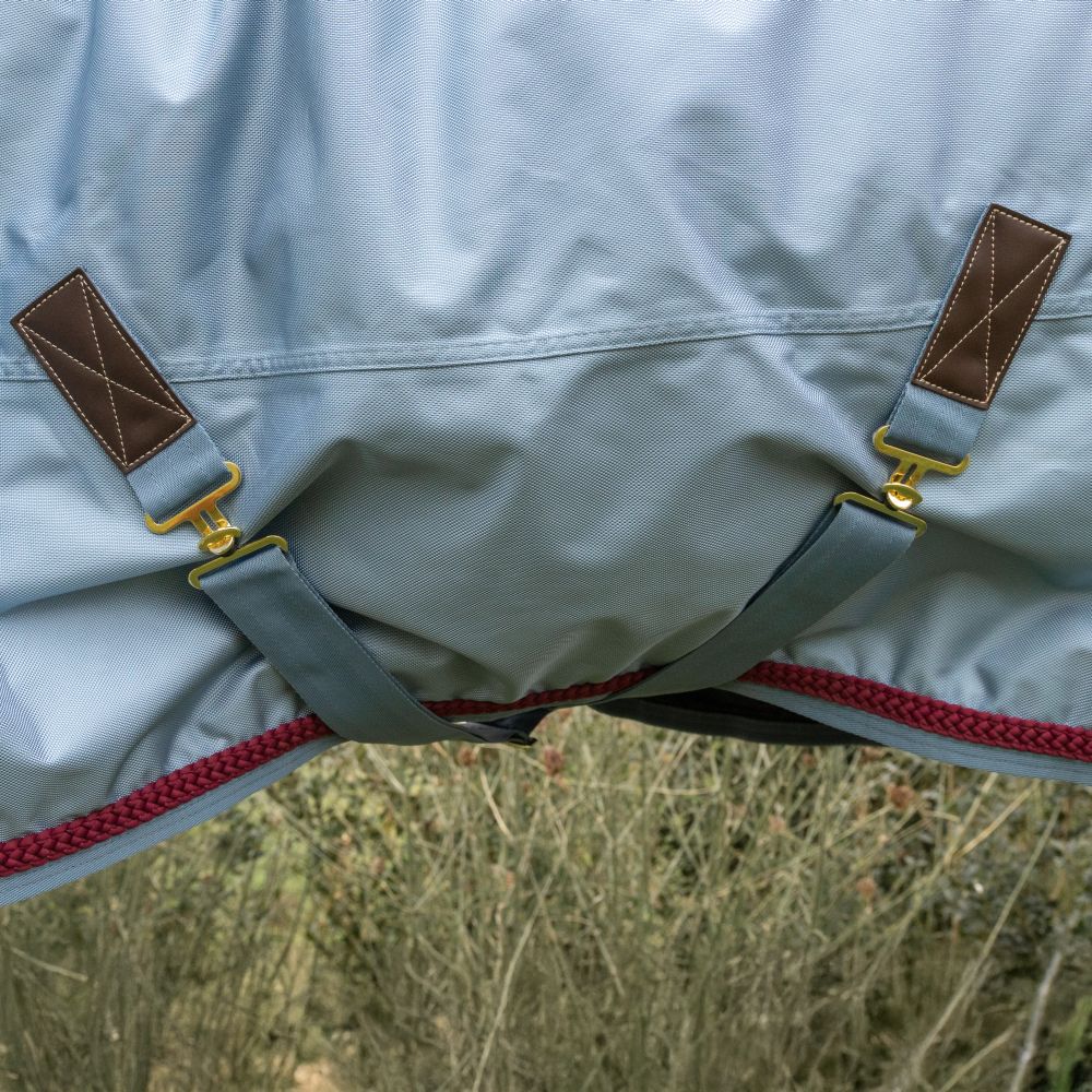 KENTUCKY® HORSEWEAR Weidedecke All Weather Waterproof Pro 160 g, denim Detailansicht der denimblauen Allwetter-Ausreitdecke Pro mit verstellbaren Beinschnüren und goldfarbenen Verschlüssen.