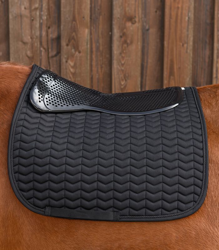 Schwarzes Waldhausen Gel-Pad Basic, perforiert, auf einer gesteppten Schabracke auf dem Rücken eines Pferdes.