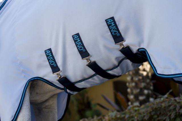 Detailansicht der azurblauen Amigo Ripstop Hoody Pferdedecke mit marineblauen Befestigungsgurten am Pferd.