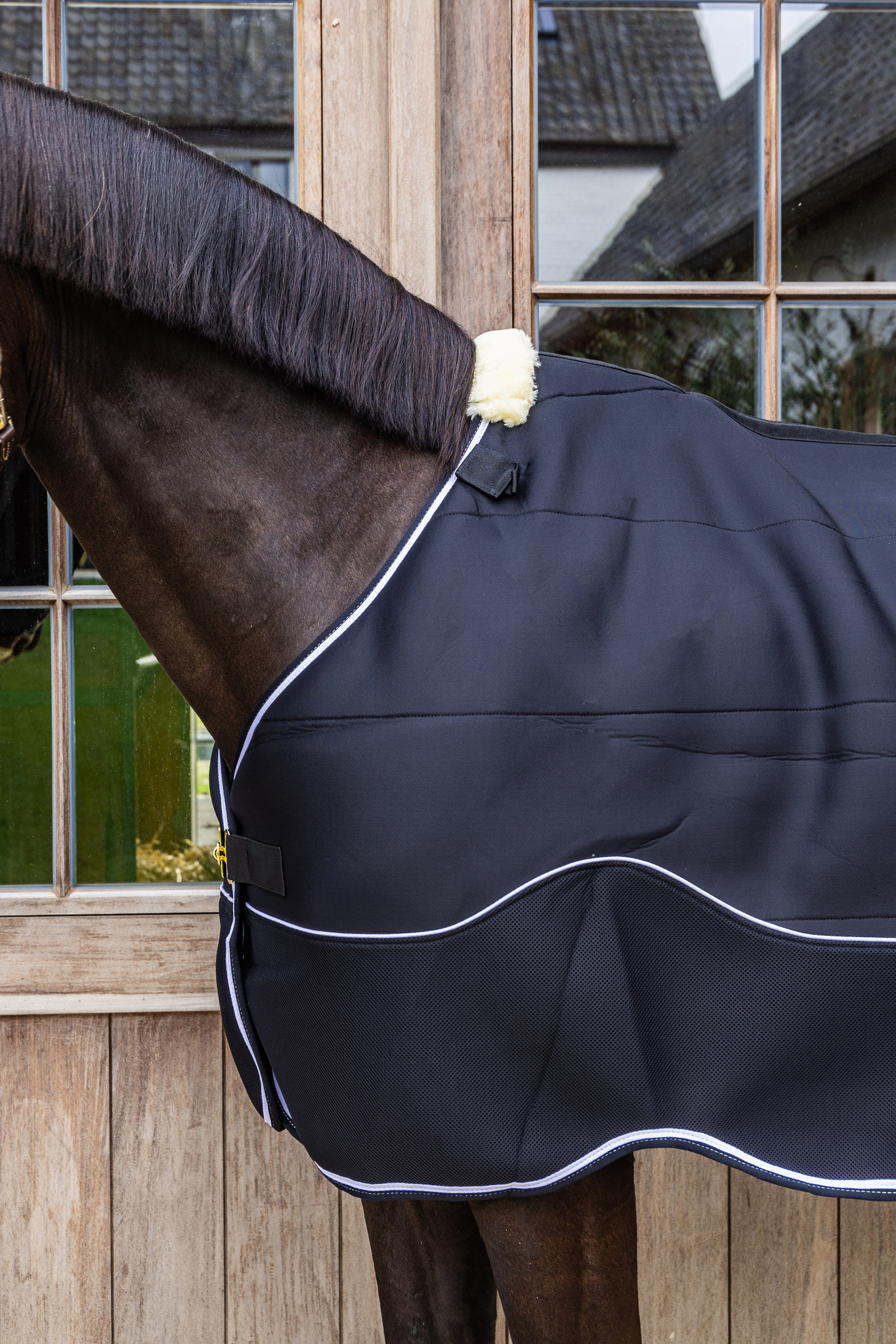 KENTUCKY® HORSEWEAR Turnout Rug Comfort 3D Fleece Liner, schwarz Schwarze Turnoutdecke Comfort 3D Fleece Liner mit weißer Biese und Widerristpolster am Pferd in Seitenansicht.