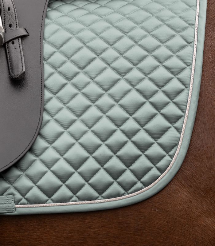 WALDHAUSEN Schabracke Felix Glam Dressur in Silberblau mit Rautensteppung und Zierkordel unter dem Sattel.