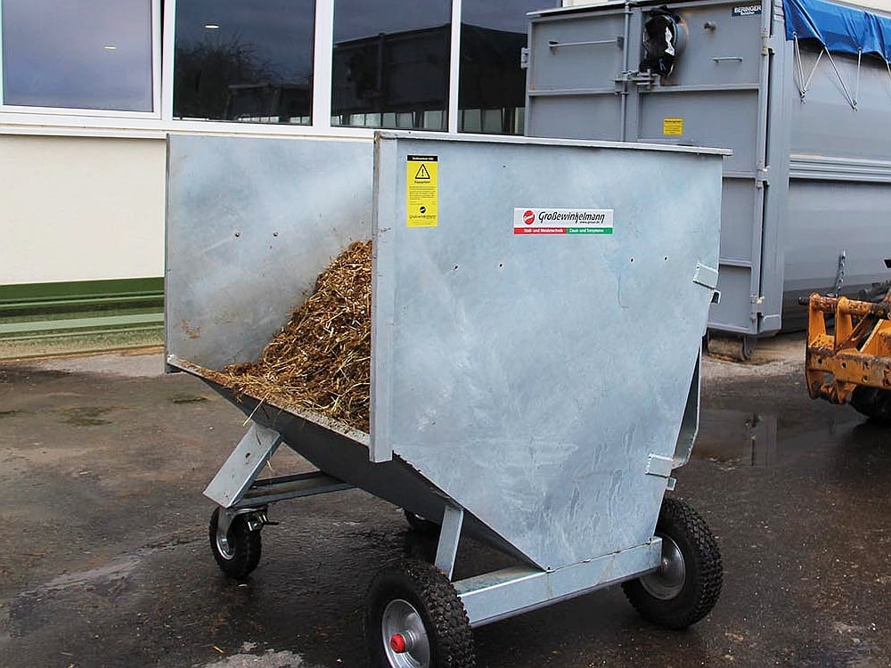 GROWI Großraumkuli für Hoflader aus verzinktem Stahl, mit vier Rädern und teilweise mit Stroh befüllt