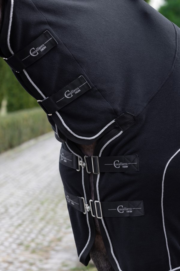 Schwarze CovallieroTherm Fleecedecke mit Halsteil am Pferd, Nahaufnahme der verstellbaren Brustverschlüsse.