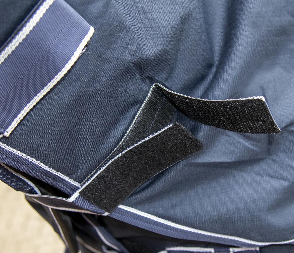 HKM Weidedecke Starter mit Halsteil und Polarfleece, dunkelblau Detailansicht des schwarzen Klettverschlusses der dunkelblauen HKM Starter Fleecedecke mit Halsteil und weißen Nähten.