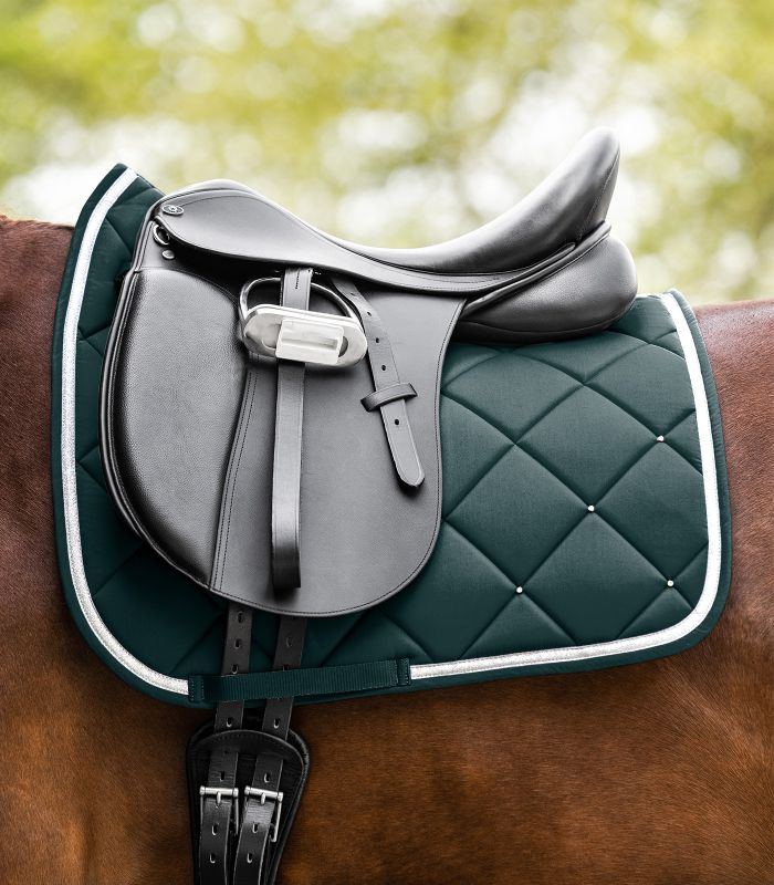 Waldhausen Competition Dressur Schabracke in Tannengrün mit Rautensteppung, Strass und silberner Kordel am Pferd.