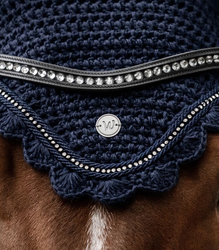 WALDHAUSEN Fliegenohren Nepal, nachtblau Nahaufnahme der nachtblauen Waldhausen Fliegenohren Nepal. Gehäkelt mit Strasssteinen und Logo am Pferdekopf.