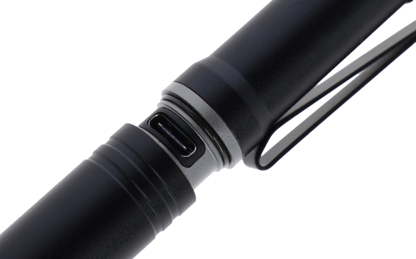 Nahaufnahme einer schwarzen LED-Taschenlampe aus Metall mit integriertem USB-C-Ladeanschluss und Halteclip.