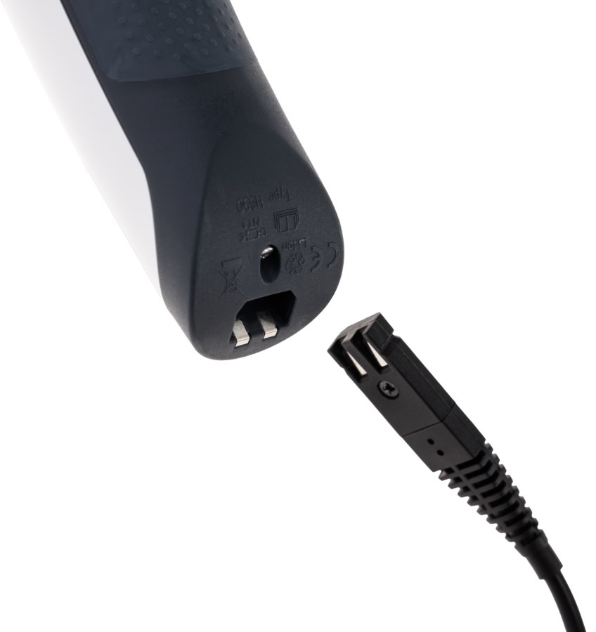 Ladeanschluss der AESCULAP Akkuschermaschine Vega II am anthrazit-weißen Gehäuse mit dem schwarzen Ladekabel