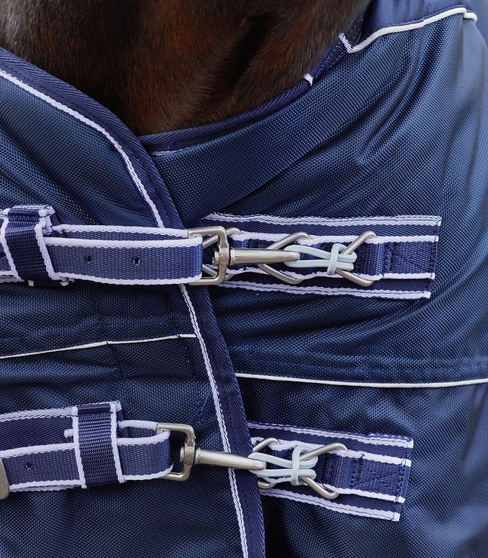 WALDHAUSEN Safe-Gum, 18er Set gemischt Silbergraue Safe-Gum Gummiringe als flexible Verbindung an den T-Haken-Verschlüssen einer dunkelblauen Pferdedecke.