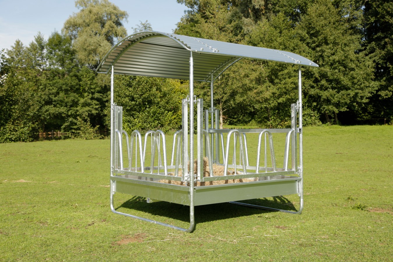 Kerbl Viereckraufe Standard mit Palisadenfressgitter und Dach aus verzinktem Metall auf einer grünen Wiese.