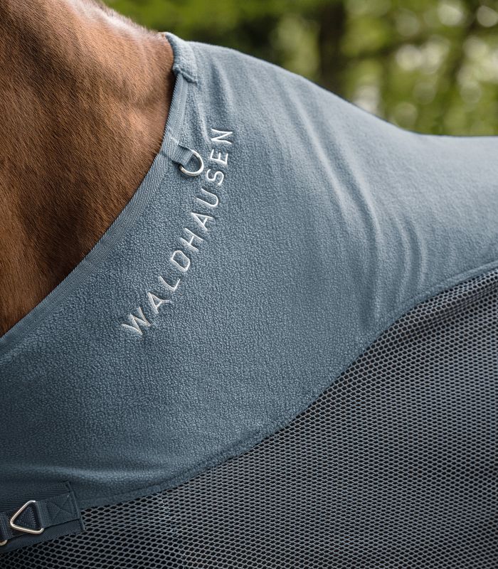 WALDHAUSEN COMFORT Fleece-Fliegendecke, kreideblau Detailansicht der COMFORT Fleece Fliegendecke in kreideblau mit Widerristpolster und Waldhausen-Logo auf dem Pferd.