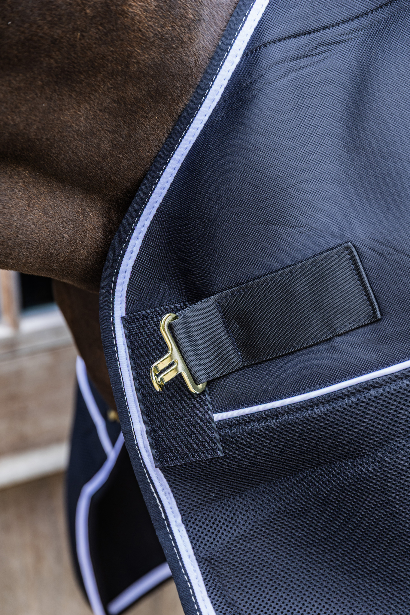 KENTUCKY® HORSEWEAR Turnout Rug Comfort 3D Fleece Liner, schwarz Schwarze Turnoutdecke Comfort mit 3D Fleece Liner am Pferd, Nahaufnahme des goldenen Verschlusses am Halsbereich.